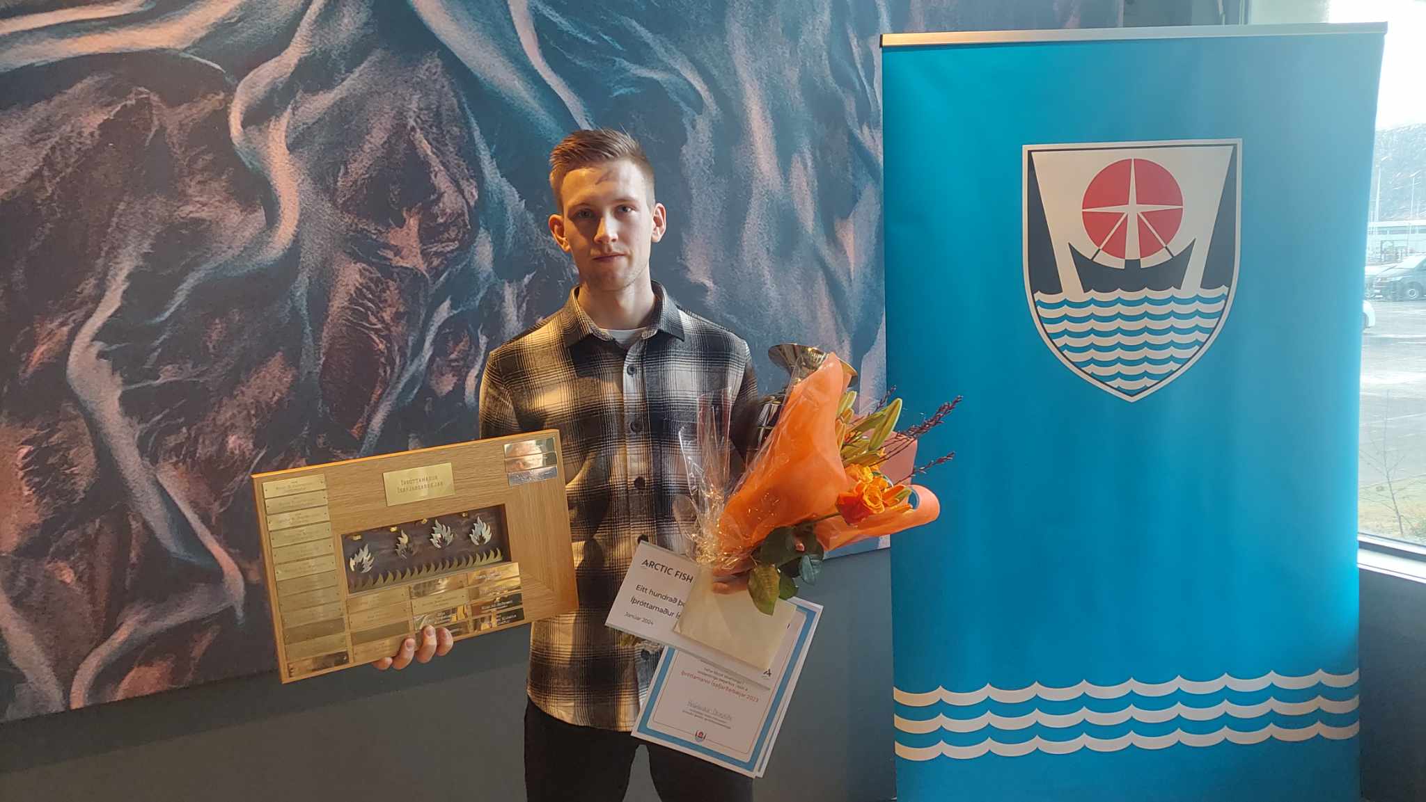 Elmar Atli Garðarsson, íþróttamaður ársins, með verðlaunagrip, viðurkenningarskjöl og blóm í fanginu.