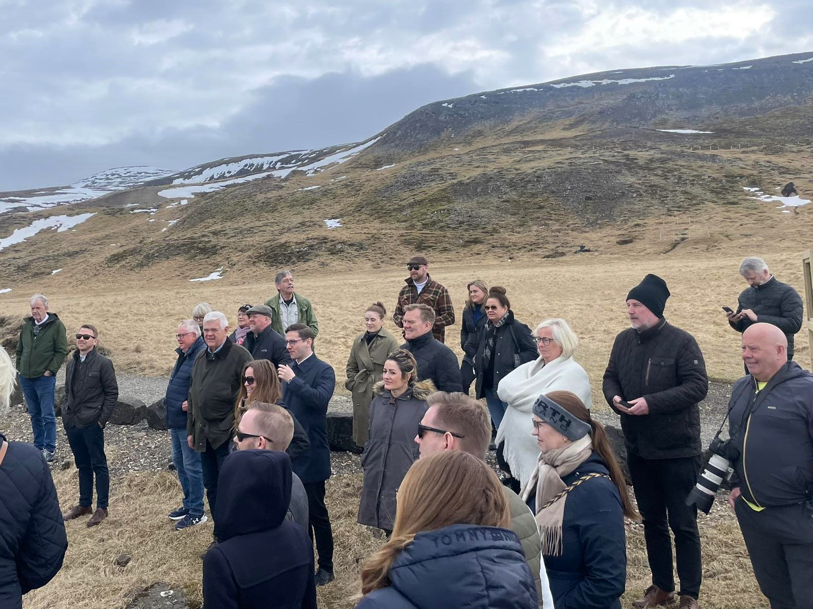 Sveitastjórar í heimsókn í Múlaþingi. Hópur fólks stendur úti, fyrir aftan þau er göngustígur, grasflötur og fjall.