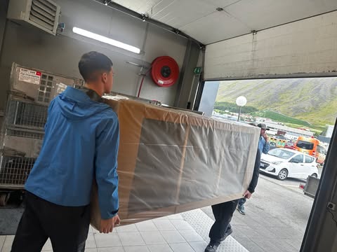 Nemendur bera sófa út af pósthúsinu á Ísafirði.